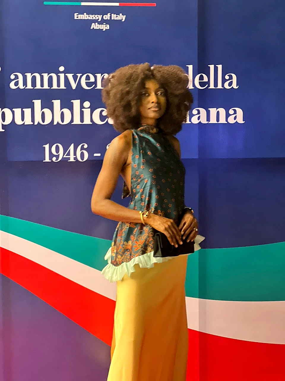 Model wearing a modern halter top in traditional prints paired with a long yellow silk skirt